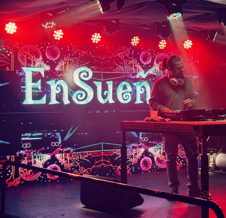 DJ EnSueño performing with dramatic red lighting and EnSueño branding displayed
